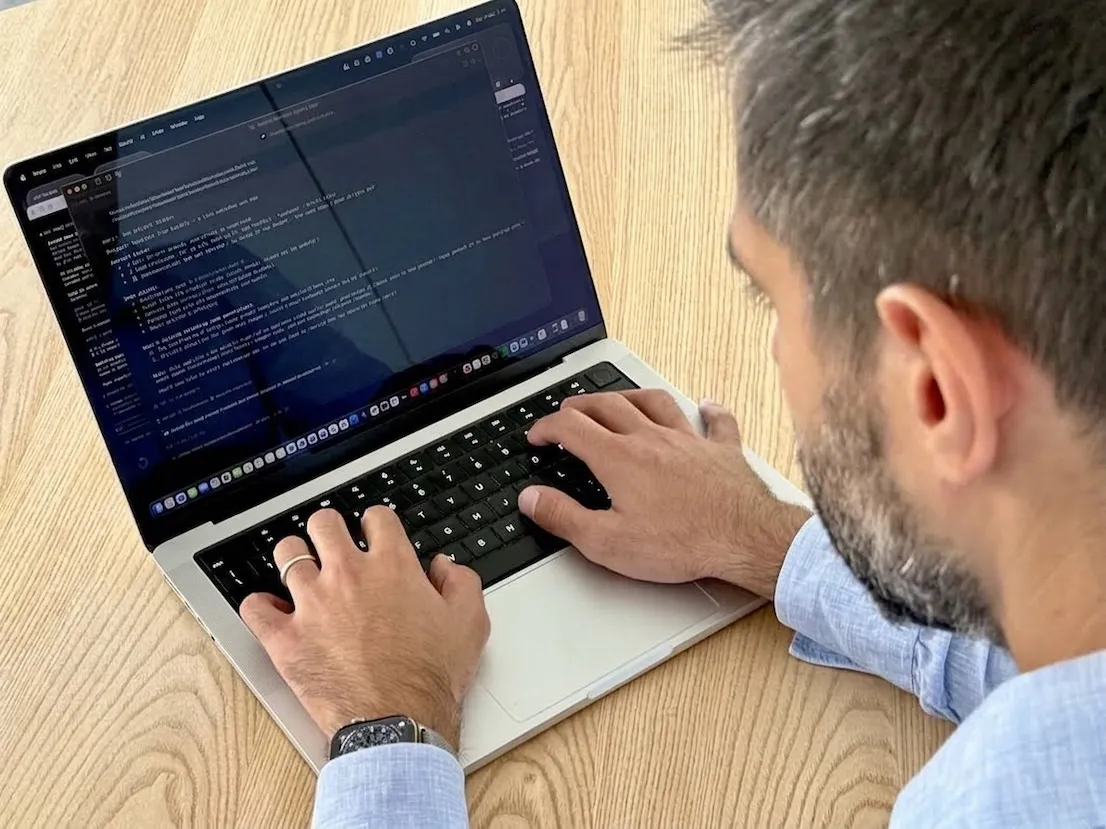 Sviluppatore al lavoro su un portatile con codice sullo schermo